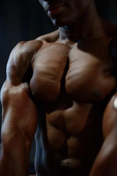 Close-up de homem afro-americano modelo nu tronco posando e mostrando músculos perfeitos do corpo em detalhes — Fotografia de Stock