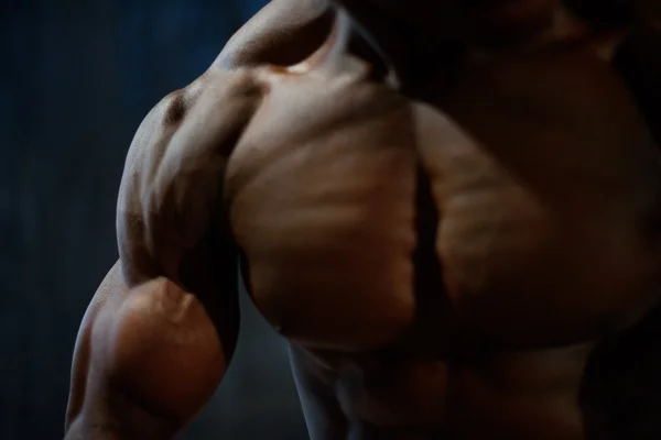 Grande close-up de músculos afro-americano homem modelo posando com torso nu no fundo do estúdio preto — Fotografia de Stock