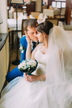 Yavaşça onun şık giyimli damat öpüşme güzel beyaz elbiseli çekici gelin