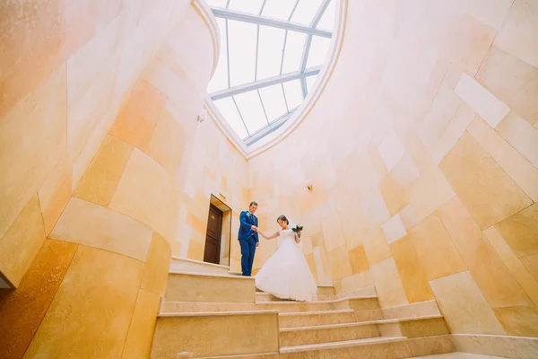 Casal romântico em escadas de mármore com paredes de arenito no fundo. ângulo baixo — Fotografia de Stock