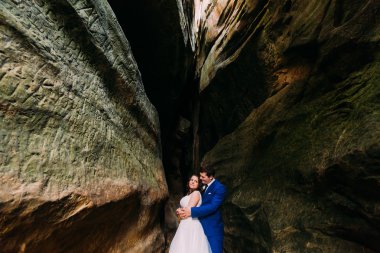 Yarık karanlık kumtaşı içinde poz genç ve onun sevgi dolu ile romantik gelin damat