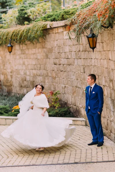 Casal bonito elegante, noiva alegre dançando para o noivo amoroso perto da parede de arenito — Fotografia de Stock