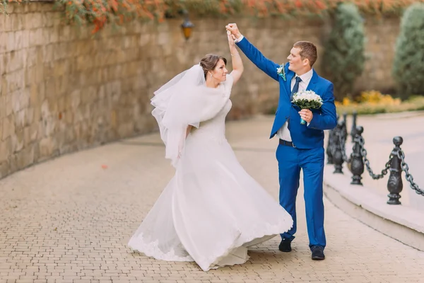 Zarif güzel düğün çift, Park kumtaşı duvarının yakınında geziniyor — Stok fotoğraf