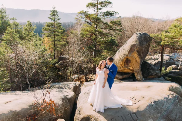 Momento romántico de pareja recién casada de pie sobre roca rocosa. Paisaje de montaña —  Fotos de Stock