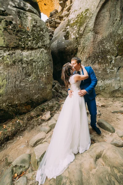 Jong en romantische jonggehuwde paar zoenen verweerde rock gespleten — Stockfoto