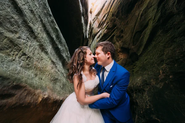幸福的新婚夫妇在亲吻风化黑岩石裂 — 图库照片