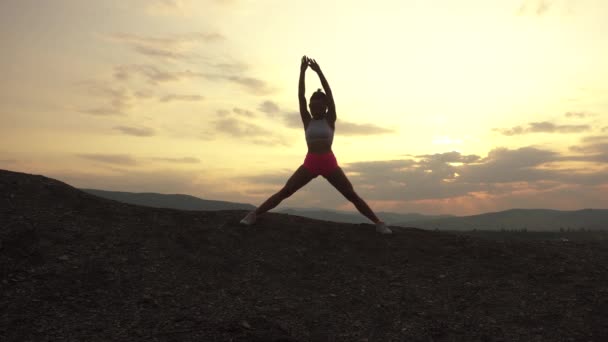 Silhouette of sexy muscular woman with perfect body stretching outdoor on sunset. Fitness concept — Stock Video