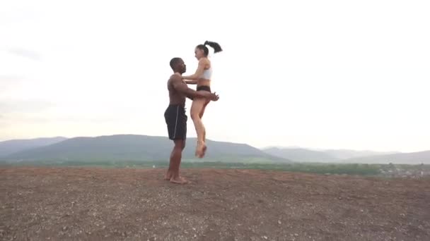 Pareja atlética mixta de gimnasia bailando en la cima de la montaña. Gracia y belleza del cuerpo humano — Vídeo de stock