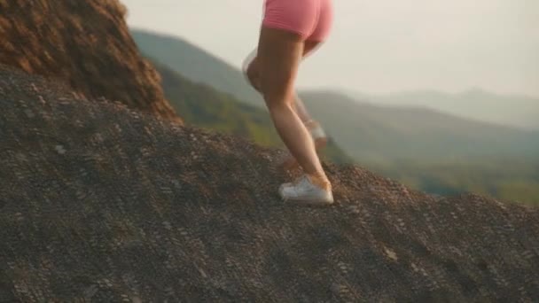 Close-up back view of sexy fit brunette woman with perfect muscular body in sportswear jogging outdoor on sunset. Mountain landscape background — Stock Video