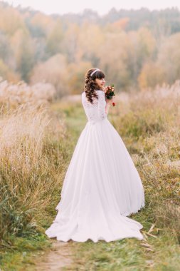 Genç gelin açık havada poz. Arka plan üzerinde orman hills ile sevimli sevimli kız