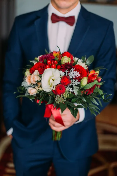 Jovem elegante segurando buquê de casamento de flores vermelhas e brancas — Fotografia de Stock