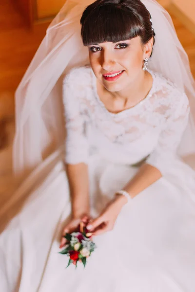 Sposa eccitata in splendido abito bianco in attesa del suo matrimonio in posa con carino boutonniere floreale — Foto Stock