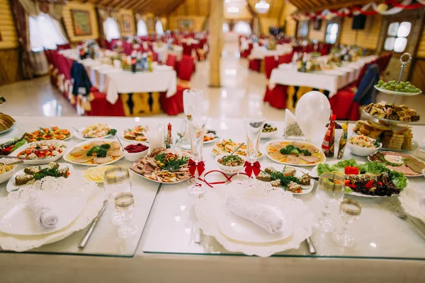 Stołu biesiadnego restauracji serwowane do świętowania. Zbliżenie na różnych żywności, szklanki i talerze — Zdjęcie stockowe