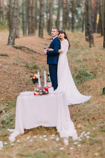 Romântico pinhal outono picknick floresta de noiva recém-casada feliz e noivo celebrando seu casamento — Fotografia de Stock