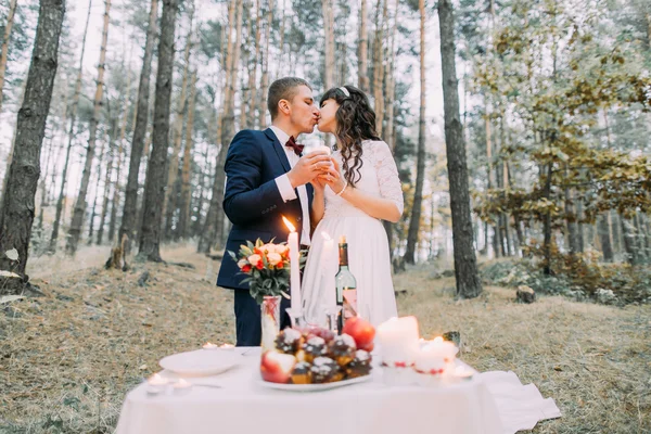 Pinheiro de outono romântico picknick floresta. Feliz casal recém-casado se beijando celebrando seu casamento — Fotografia de Stock