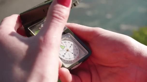 Flickorna händerna öppna multifunktionella kompass enhet. Extrem närbild med flod bäcken vid bakgrund — Stockvideo
