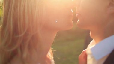 Romantik yeni evliler şefkatle muhteşem günbatımı sırasında birbirlerine öpüşme