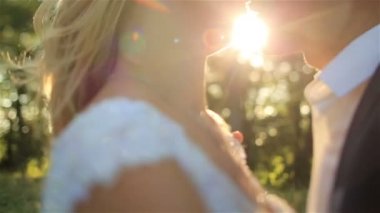 Güzel genç düğün çift tutkuyla birbirinizi muhteşem günbatımı sırasında öpüşme