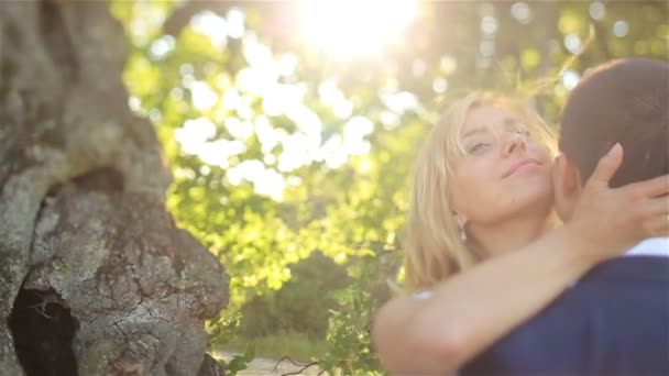 Vackra unga blonda brudparet stilig embracing vid solnedgången i park närbild — Stockvideo