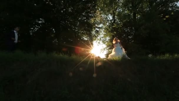 Bella bionda sposa e sposo ballare all'aperto nella luce del tramonto, guardando felice al loro matrimonio — Video Stock