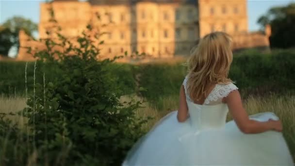 Чудовий молода блондинка нареченої позують проти старого середньовічного замку в Західній Україні — стокове відео