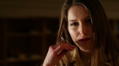 Çekici genç kadın seductively yüz ve kamera için poz dokunur. Siyah arka plan