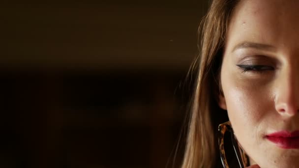 Κοντινό πλάνο πορτρέτο του σαγηνευτική ξανθιά κοπέλα με κόκκινα χείλη ποζάρουν για την κάμερα. Μαύρο φόντο — Αρχείο Βίντεο