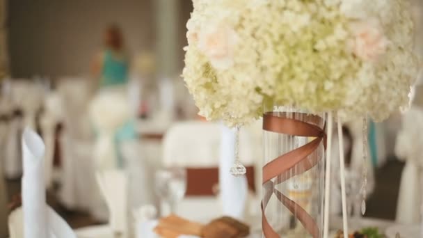 Salón de banquetes preparado para la celebración. Mesa de boda, decorada con composición floral, lista para el evento — Vídeos de Stock