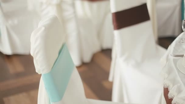 Geschmückter Hochzeitssaal für die Feier vorbereitet. Stühle in Stoffdekoration mit farbigen Bändern — Stockvideo