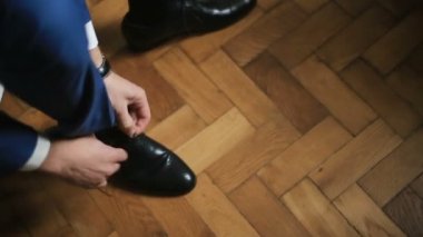 Damat ayakkabı kapalı beyaz ahşap zemin üzerine giyiyor