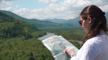 Harita ayakta highland nehir manzara dezavantajı ile onun yol kontrol güneş gözlüklü genç kadın