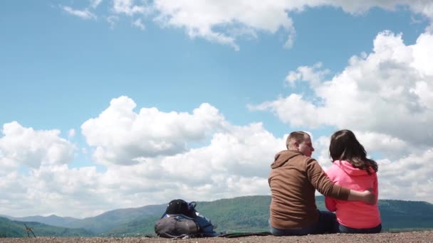 Ung attraktiv turist par kramas och kyssas på fantastiska himmelsblå bakgrund — Stockvideo