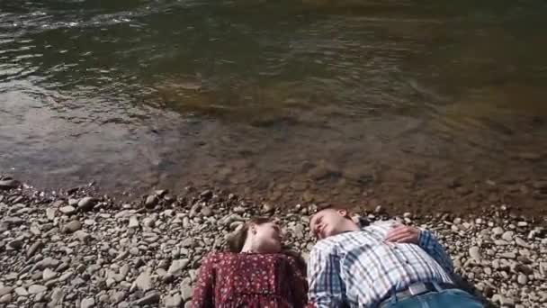 Jeune couple au bord de la rivière. Beaux hommes plie jeune fille, puis l'embrasse doucement dans les lèvres — Video