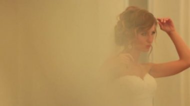 Kapalı yumuşak sarı ışık ile poz güzel şehvetli sarışın gelin. Beyaz elbise genç kadının şehvetli hamle