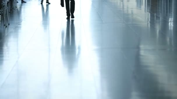 Passengers in airport transit terminal. Silhouette of young business man walking to camera with suitcase for travel — Stock Video