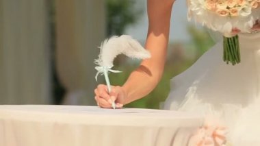 Gelin ve damat kalem alır ve düğün sertifika işaretleri