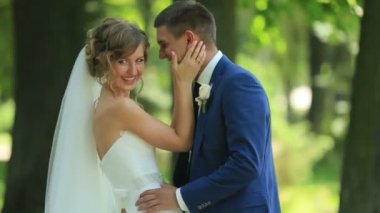 Şık yakışıklı damat güzel gelini kucaklayan, onu boynundan öper