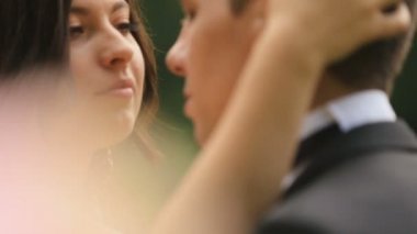 Mutlu yeni evli gelin ve damat sevgiyle birbirine tutarak. Açık yaz park ile arka plan olarak vurdu.