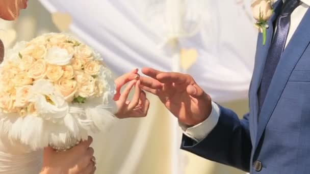 Közelkép a vőlegény és a menyasszony esküvő gyűrű cseréje. Szerelmes pár — Stock videók