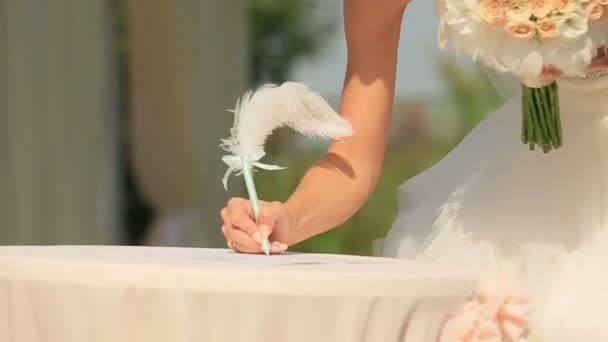 Nevěsta a ženich bere pero a podepíše certifikát svatební