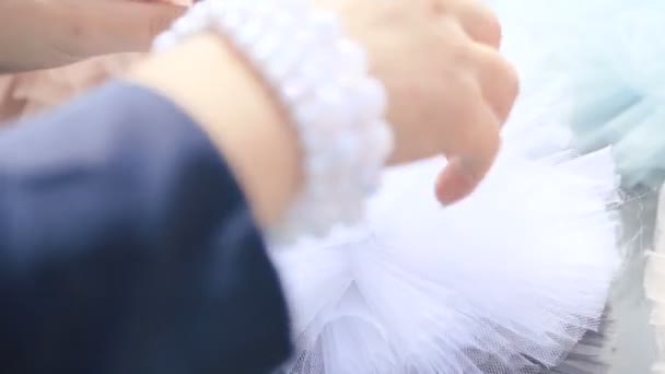 Mujeres manos con hermosa pulsera de perlas haciendo decoración de ropa para la celebración de la boda — Vídeos de Stock