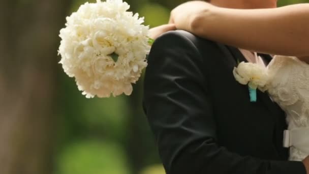 Feliz recém-casados abraçando e se divertindo. Tiro ao ar livre com parque de verão como fundo — Vídeo de Stock