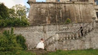 Genç Düğün çifti üzerinde eski taş merdivenle poz. Arka plan olarak harap antik kale sur