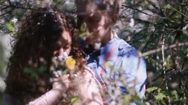 Romantik Çift kiraz çiçek açması içinde orchard ile lots-in beyaz çiçekler. Yakışıklı genç kucaklayan rüya kız