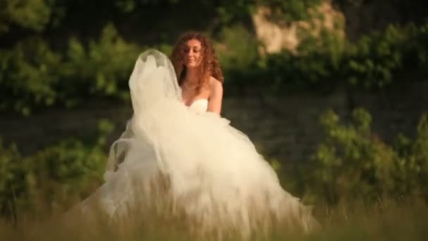 Прекрасна ніжна блондинка наречена танцює в пшеничному полі в білій весільній сукні — стокове відео