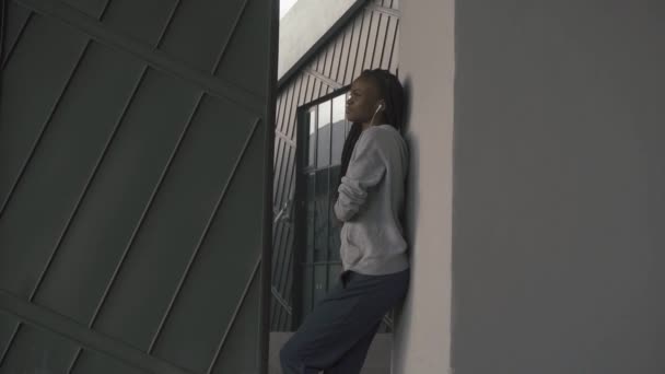 Довольно молодая африканская американка наслаждается музыкой в наушниках — стоковое видео