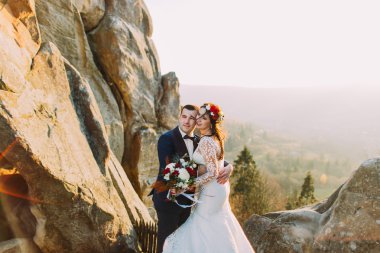 Romantik yeni evli çift arka gibi görkemli dağ manzara ile günbatımı ışıklarında birbirlerine tutarak