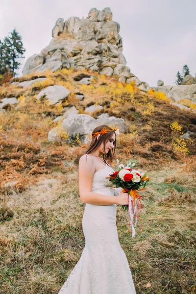 Mode romantisk vacker brud i lyxig bröllopsklänning. Leende flicka med stenar och gräs som bakgrund — Stockfoto