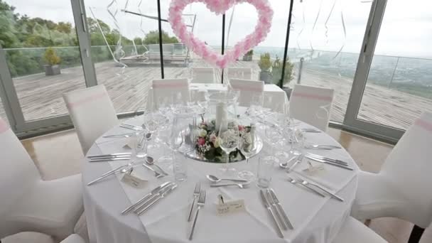 Стол накрыт гостями. Роскошный свадебный зал украшен розовыми шариками и цветами — стоковое видео