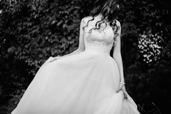 Close up of dreamy beautiful brunet bride walking alone in the park enjoying wind wave and dance — Stock Photo, Image